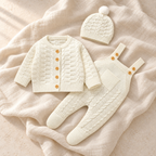 The Knit Romper & Hat Outfit — Style 04 studio flat lay on warm ivory linen