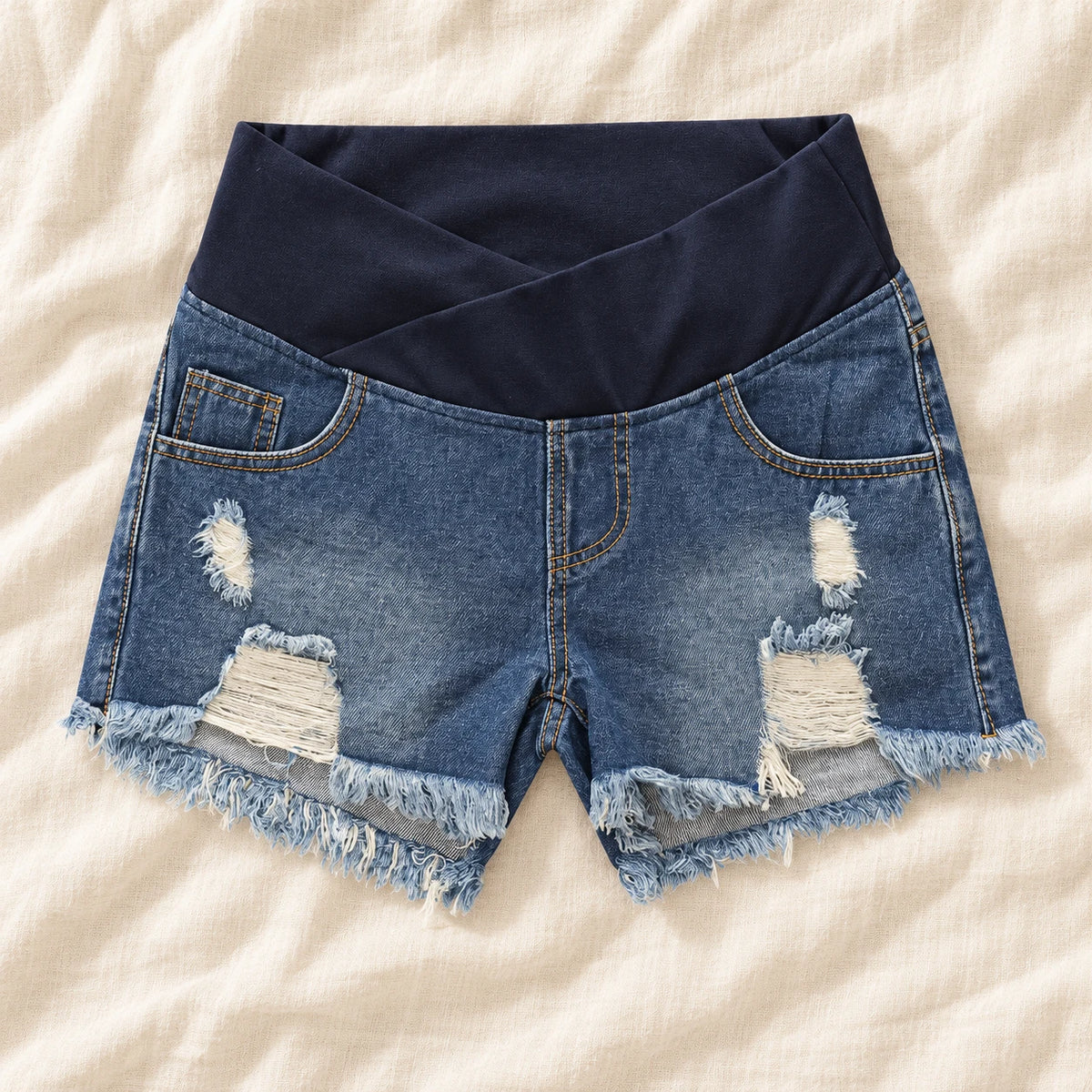 Distressed Maternity Denim Shorts — Style Dark Blue — crossover waist — on cream linen
