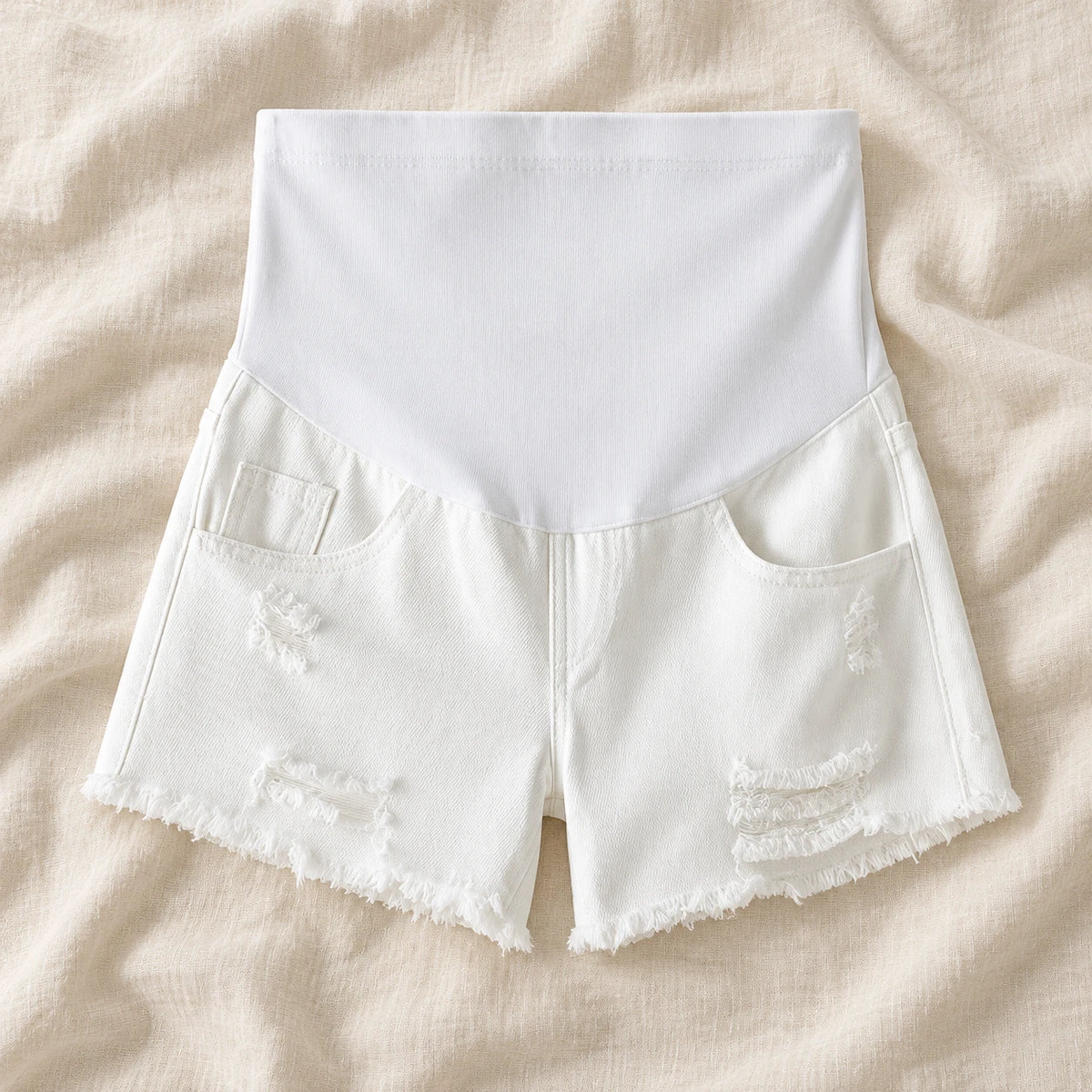 Distressed Maternity Denim Shorts — Style White — full belly panel — on cream linen