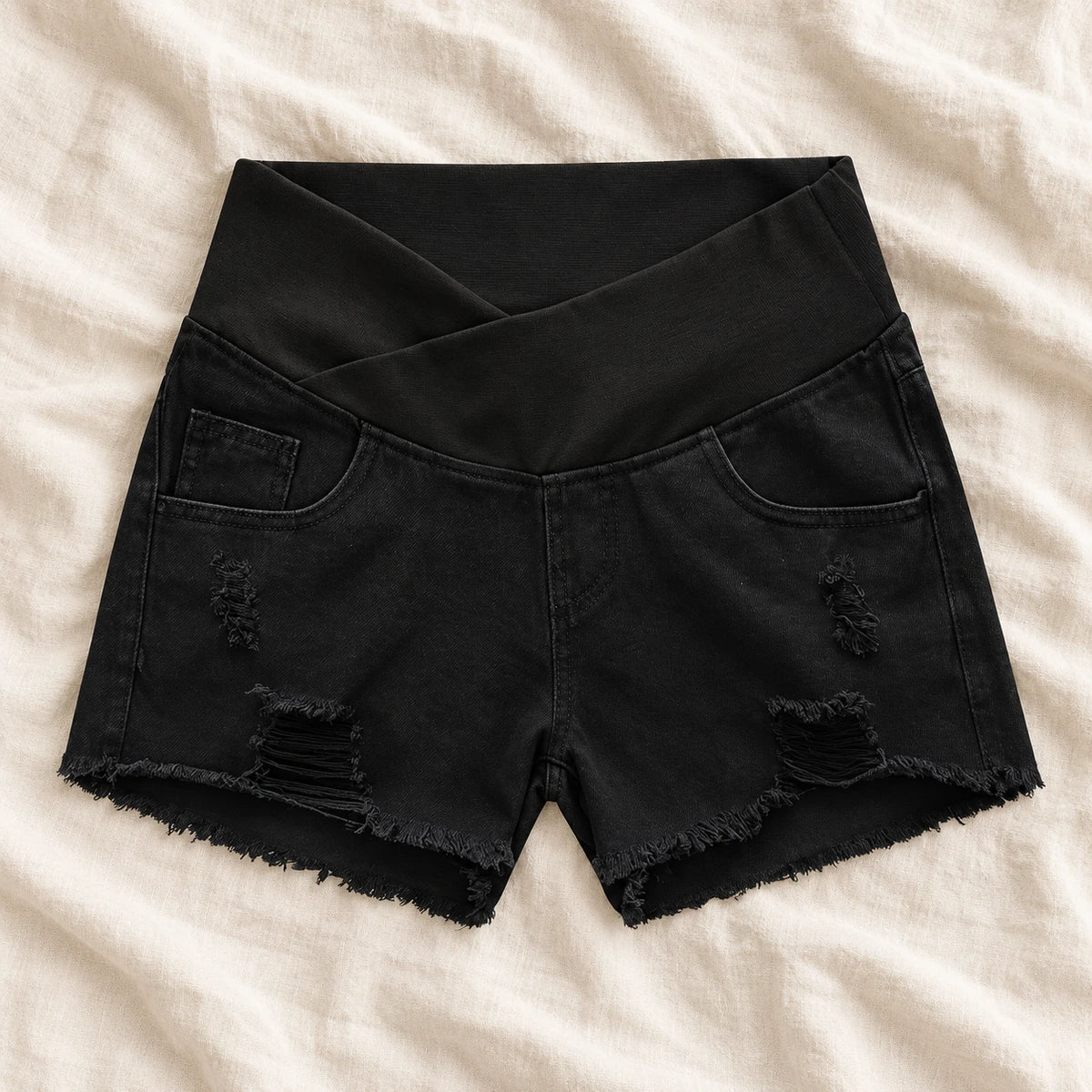Distressed Maternity Denim Shorts — Style Black — crossover waist — on cream linen