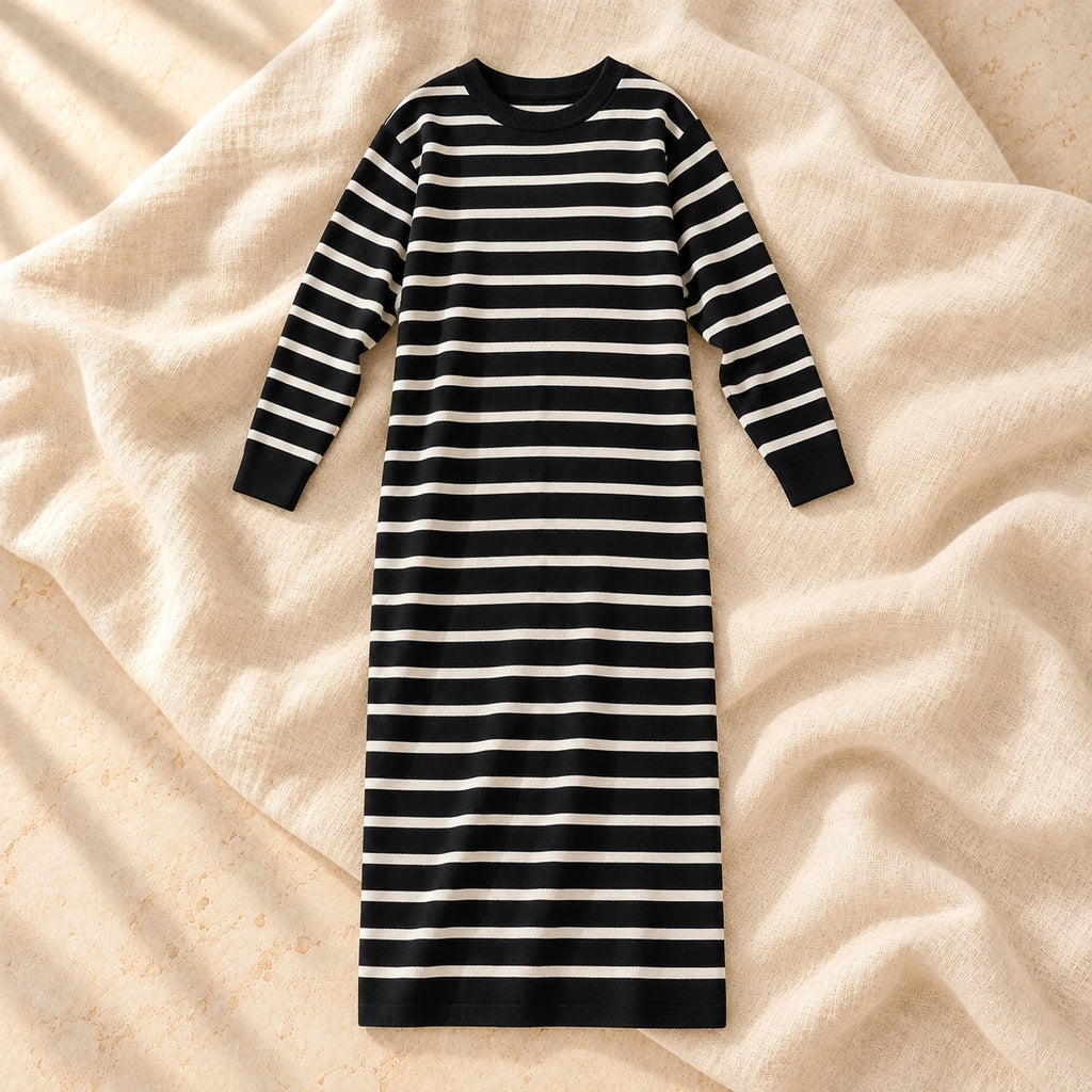 The black long-sleeve maternity maxi knit dress with ivory horizontal stripes photographed on warm cream linen