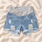 Distressed Maternity Denim Shorts — Style Light Blue — crossover waist — on cream linen