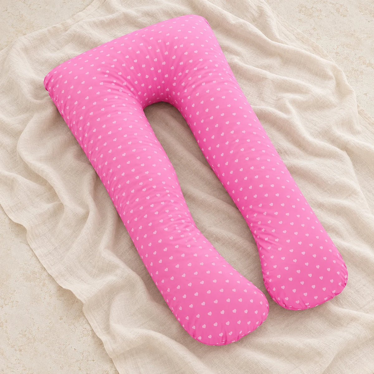 Full-body pregnancy pillow — Pink — White Hearts, product on cream linen