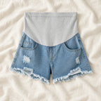 Distressed Maternity Denim Shorts — Style Light Blue — full belly panel — on cream linen