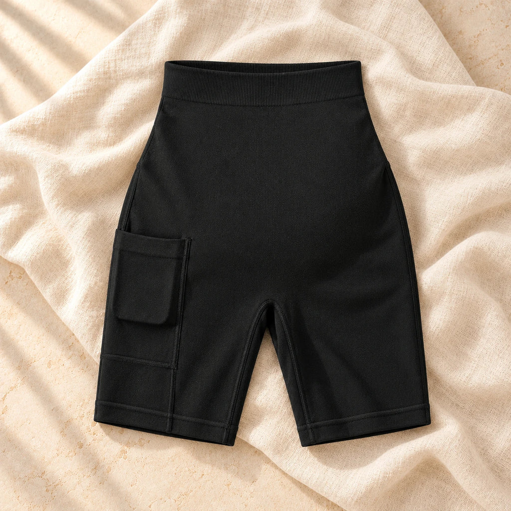 The black maternity biker shorts photographed on warm cream linen