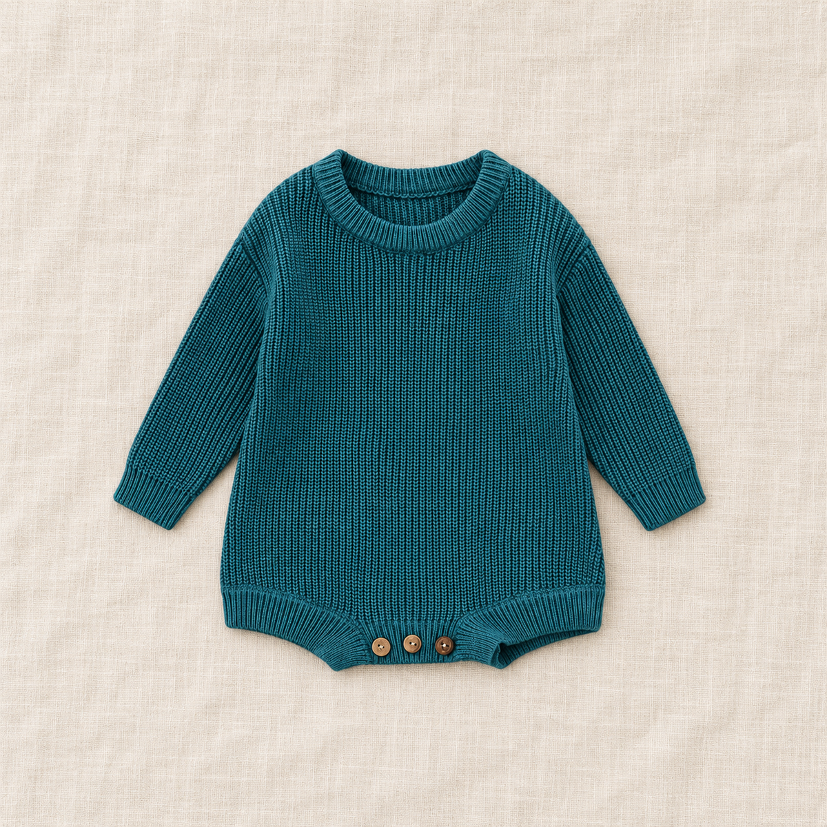 Button knit baby romper in Bluish Green, boutique studio photograph