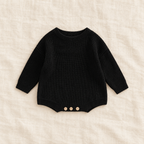 Button knit baby romper in black, boutique studio photograph