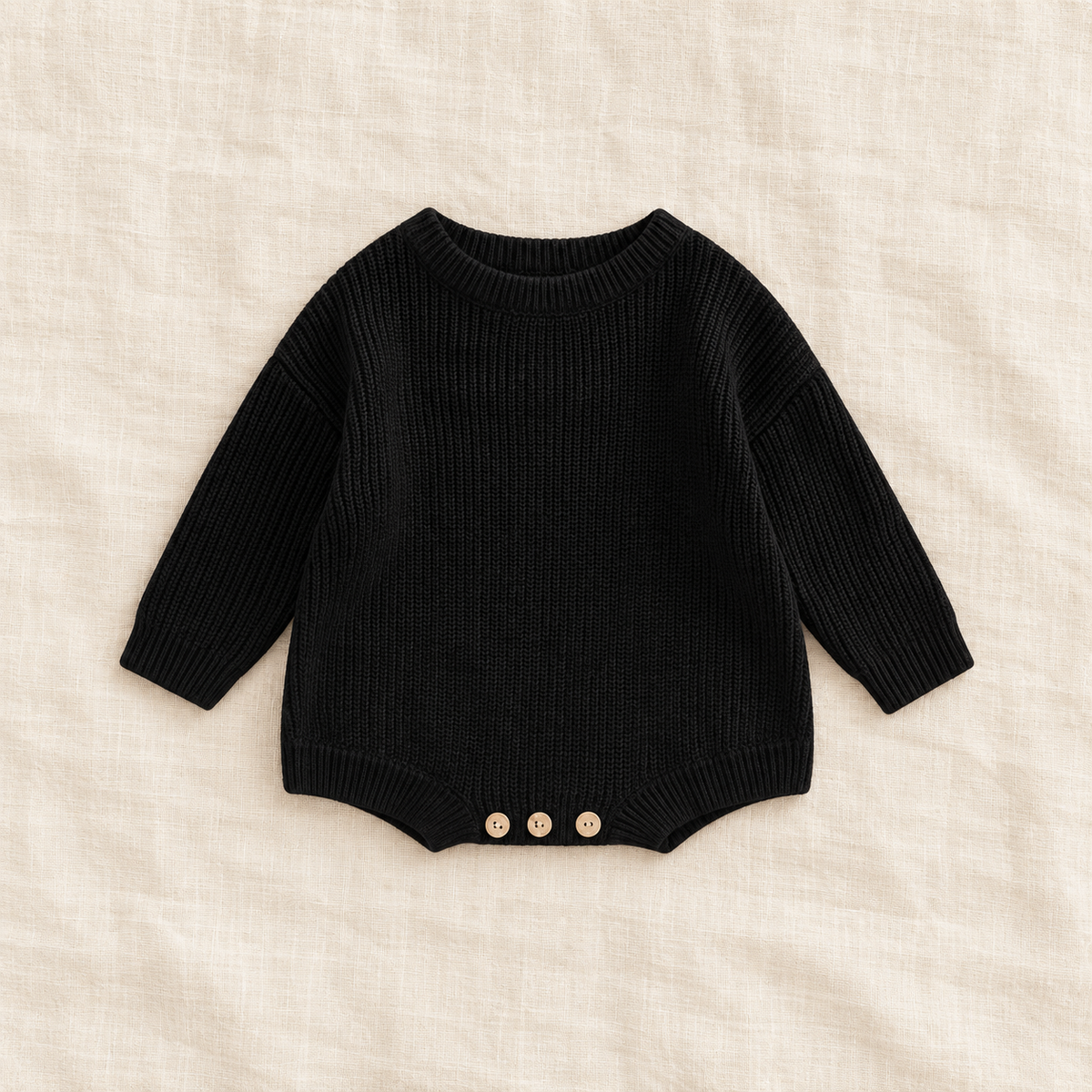 Button knit baby romper in black, boutique studio photograph