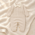 Cream cable knit baby romper with white collar on ivory linen