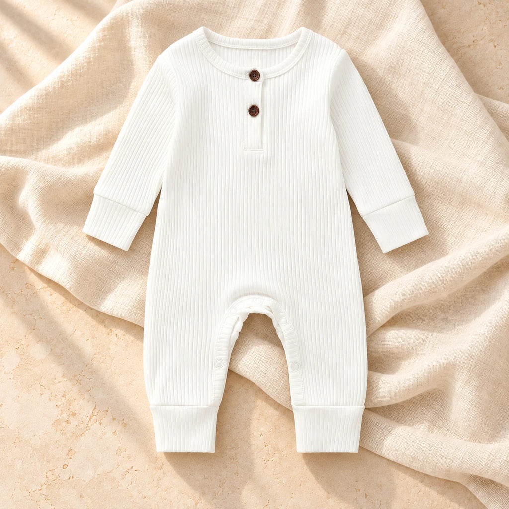 White ribbed baby romper on ivory linen