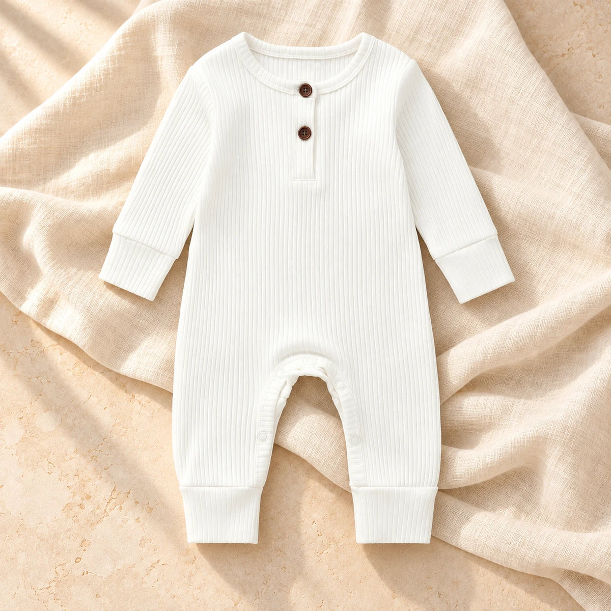 White ribbed baby romper on ivory linen