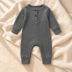 Heather gray ribbed baby romper on warm ivory linen