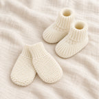 The Newborn Knit Wardrobe — cream plain booties and mittens on ivory linen