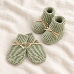 The Newborn Knit Wardrobe — sage ribbon booties and mittens on ivory linen