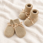 The Newborn Knit Wardrobe — sand ribbon booties and mittens on ivory linen