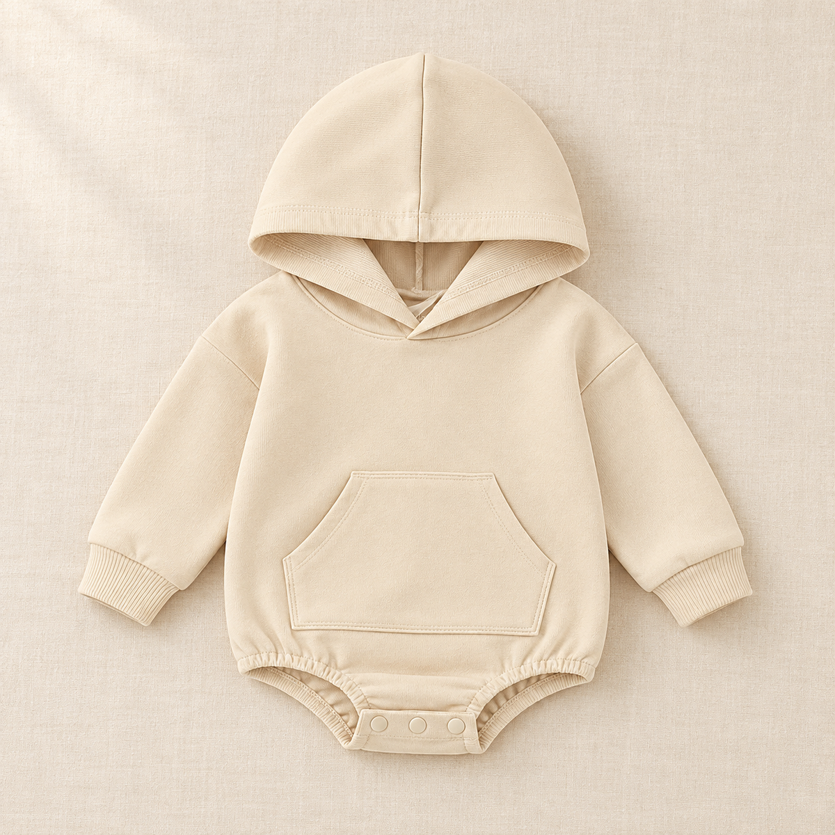 The Pocket Hooded Baby Romper on ivory linen