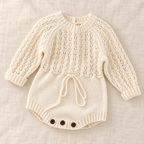 The Pointelle Knit Baby Romper on ivory linen