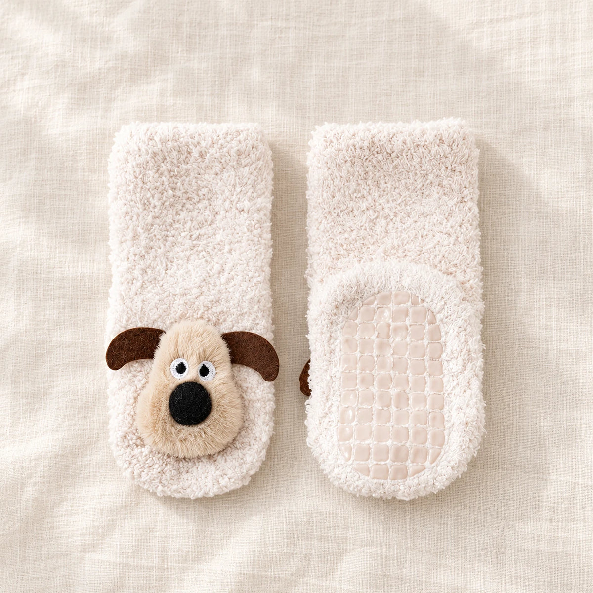 White Puppy Cozy Floor Socks with beige puppy faces and non-slip soles on ivory linen