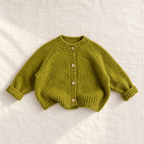 The Cozy Button Knit Cardigan — Green, laid flat on ivory linen