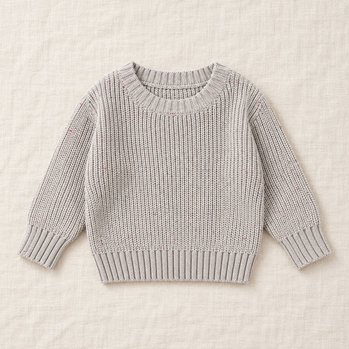 The Relaxed Rib Knit Sweater — Gray Dots, laid flat on ivory linen