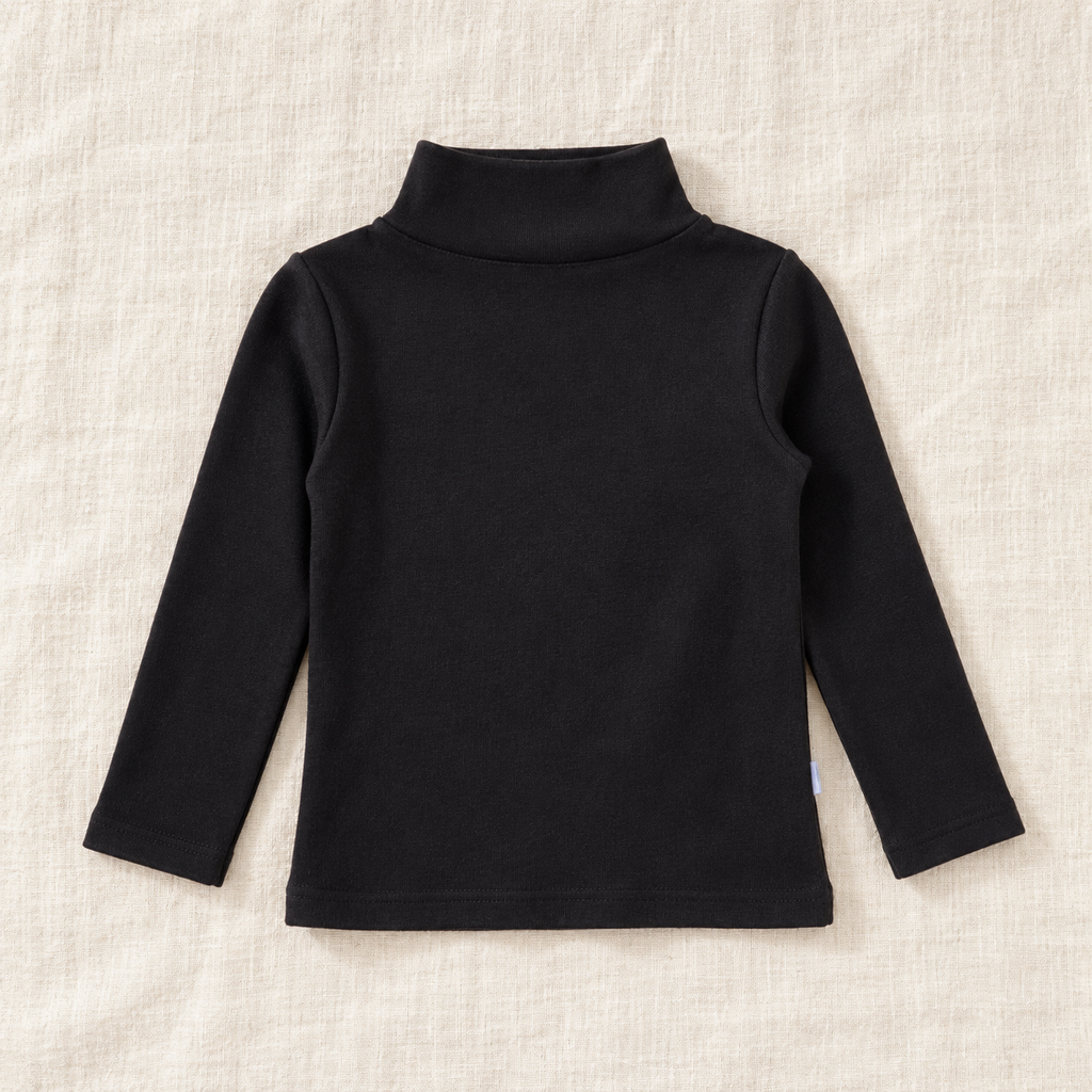 The High-Neck Layering Top — Black, laid flat on ivory linen