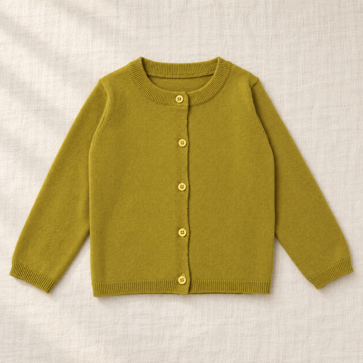 The Everyday Fine Knit Cardigan — Muted Yellow, laid flat on ivory linen