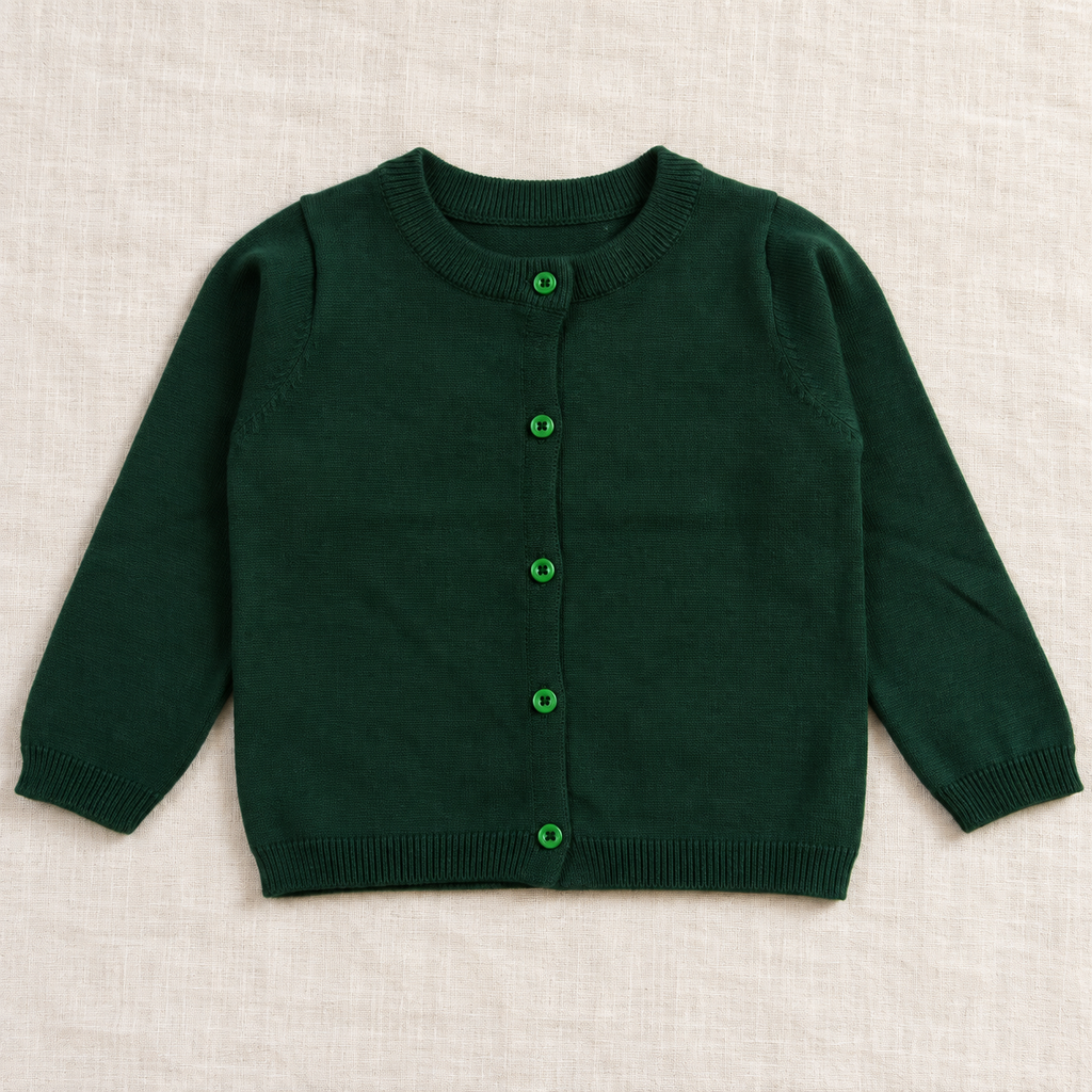 The Everyday Fine Knit Cardigan — Dark Green, laid flat on ivory linen
