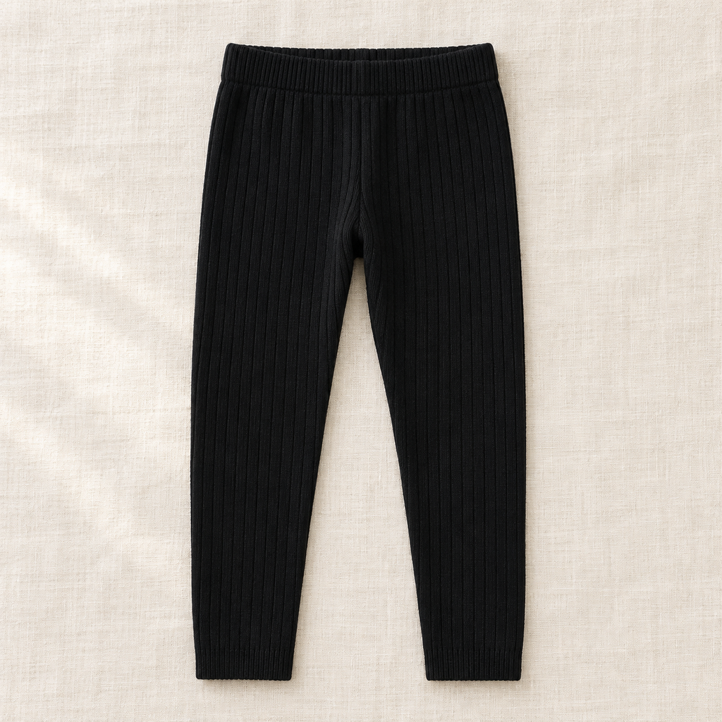 The Everyday Rib Knit Leggings — Black, laid flat on ivory linen