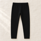 The Everyday Rib Knit Leggings — Black, laid flat on ivory linen