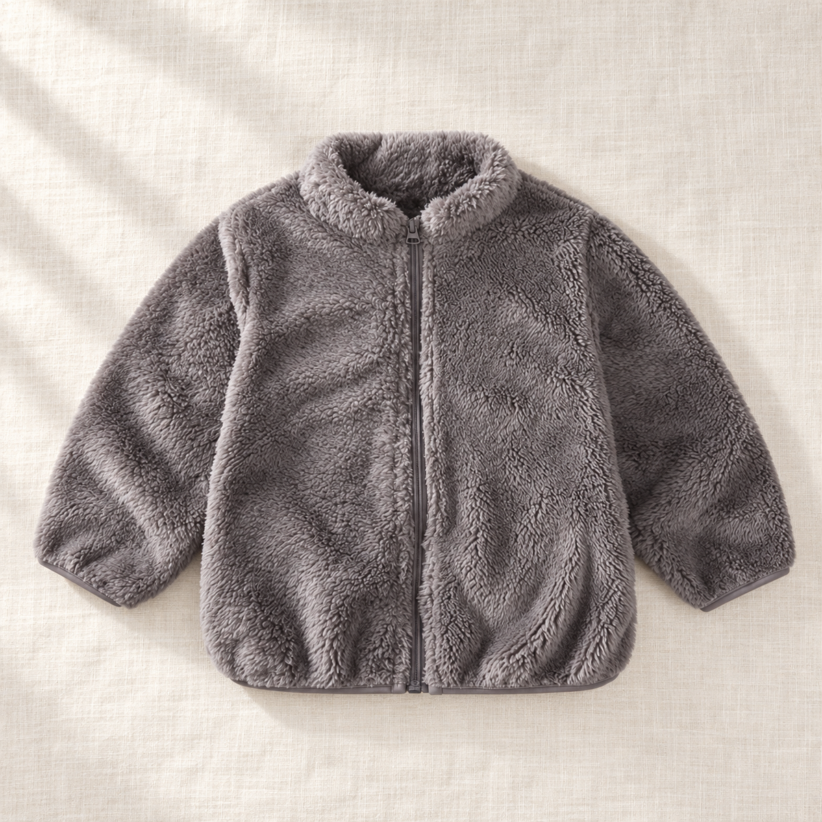 The Plush Zip Jacket — Gray, laid flat on ivory linen