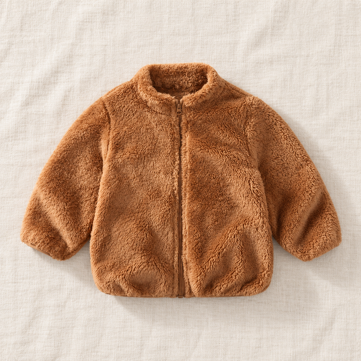 The Plush Zip Jacket — Caramel, laid flat on ivory linen