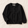 The Simple Button Knit Cardigan — Black, laid flat on ivory linen