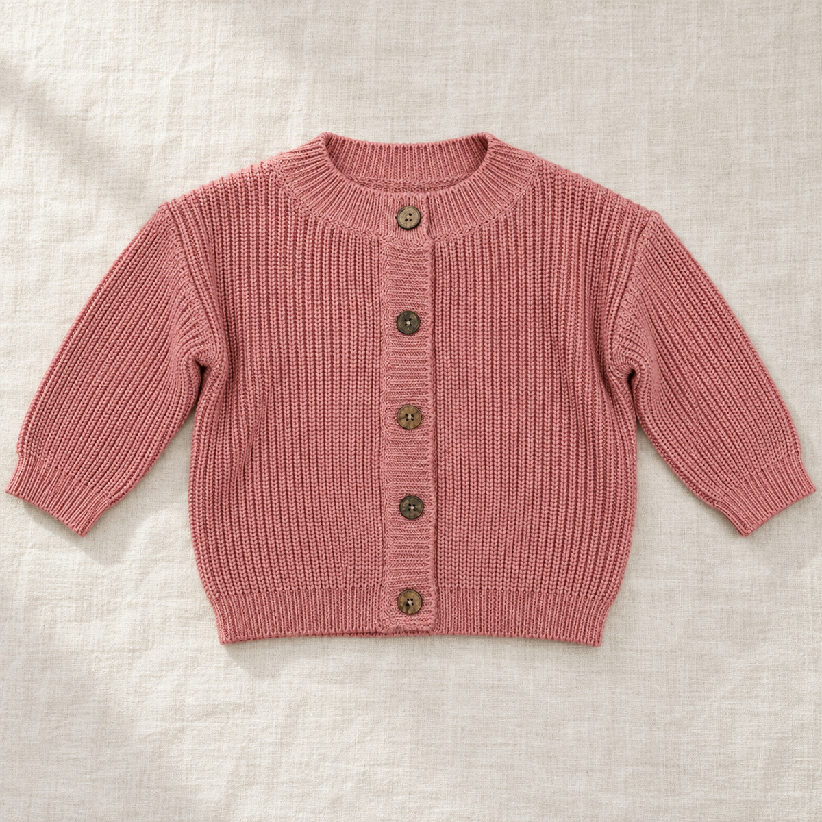 The Ribbed Button Knit Cardigan — Rose Pink, laid flat on ivory linen