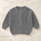 The Ribbed Button Knit Cardigan — Gray, laid flat on ivory linen