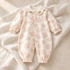 The Botanical Cotton Baby Romper studio photograph on ivory linen