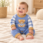 Baby wearing The Everyday Knit Baby Romper in a warm nursery