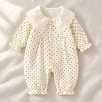 The Peter Pan Floral Baby Romper studio photograph on ivory linen