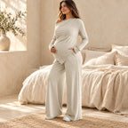 Adult model wearing the beige asymmetric maternity top and matching wide-leg trousers