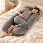 Woman resting with the grey U-shaped pregnancy pillow on cream linen