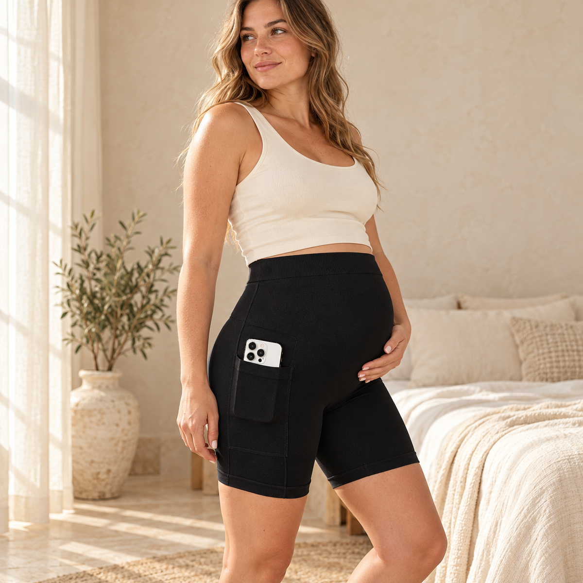 Pregnant woman wearing black maternity biker shorts with a side pocket
