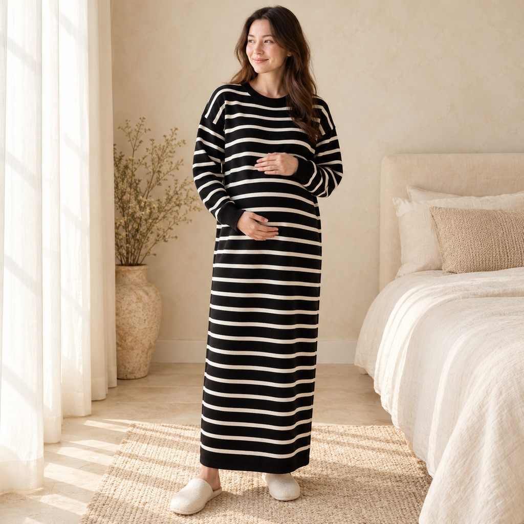 Pregnant woman wearing the black and ivory striped knit maternity maxi dress